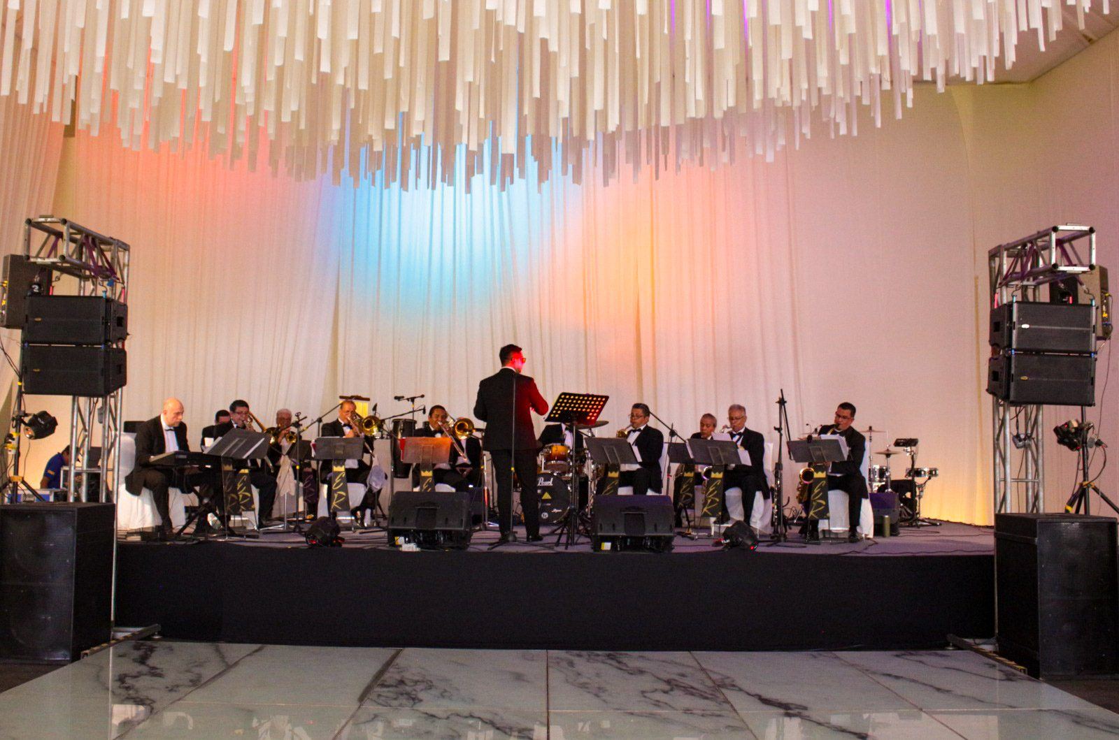 La orquesta completa tocando en el escenario de una boda