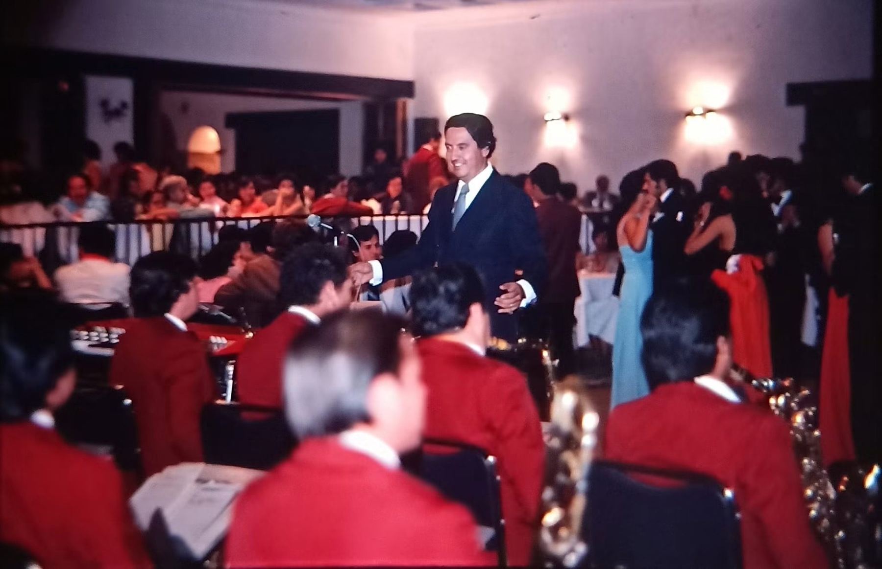 La orquesta tocando frente a un salón de gala lleno de gente bailando