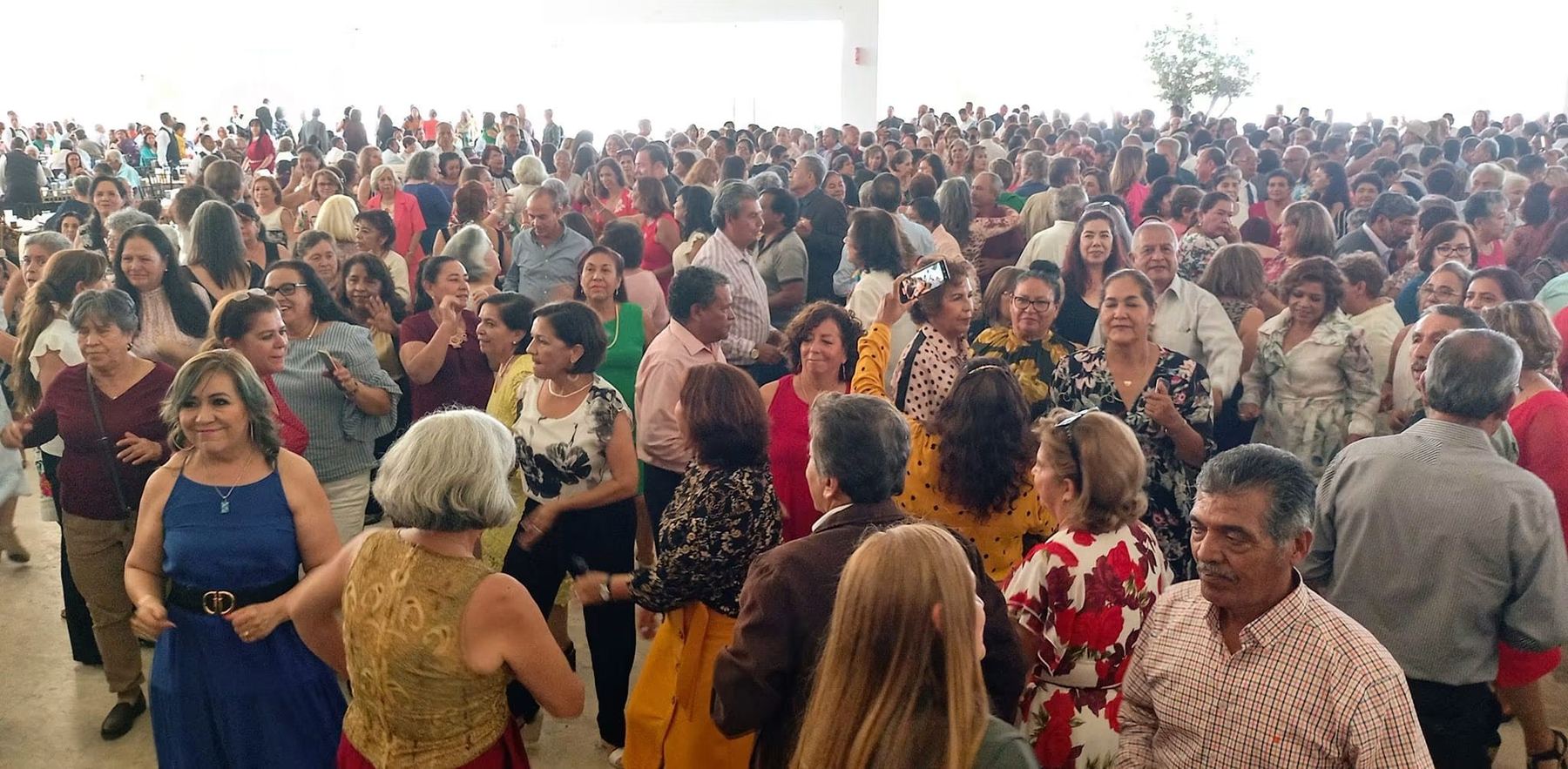Pista de baile completamente llena durante una presentación de la orquesta